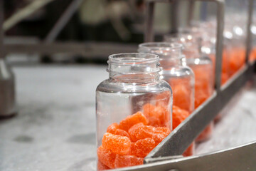 Vitamins supplements with gummy shape on the conveyor belt of the manufacturing industrial facility