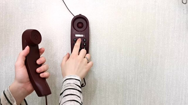close-up, hands of young woman dialing emergency number 112 on home phone. emergency call