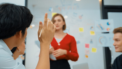 Closeup image of male project manager raise hand to ask questions while young beautiful leader presents business project with confident by using mind map and colorful sticky notes. Immaculate.
