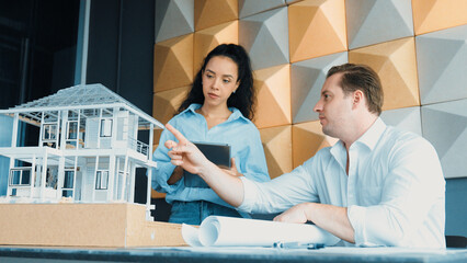 Professional diversity cooperated engineer team discuss about house material. Project manager shows...