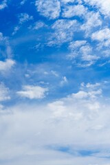 A breathtaking view of a clear blue sky adorned with fluffy white clouds, ideal for use as a background in various creative projects. This serene image evokes a sense of peace and tranquility.