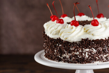 Black forest cake, Schwarzwald pie, dark chocolate and cherry on a brown background. Vegan food, sugar, lactose and gluten free.