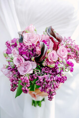 Vibrant floral bouquet featuring roses and lilacs for a special celebration in soft natural light