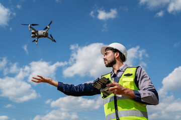 Engineer in a safety vest operates a drone to survey power lines, while a technician inspects a...