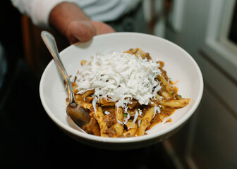Delicious pasta dish served with fresh coconut on a plate during a culinary event at a cozy restaurant