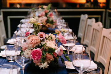 Elegant dining setup with floral centerpieces in a stylish restaurant during evening hours