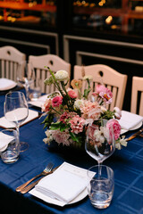 Elegant dining setup with floral centerpiece at a restaurant in the evening