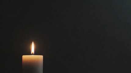 Candle flame illuminating darkness in a moment of mourning and remembrance