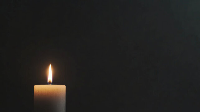 Candle flame illuminating darkness in a moment of mourning and remembrance