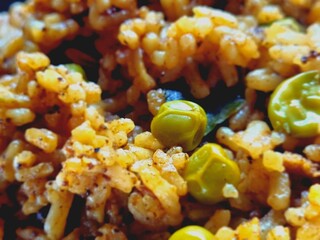 Maharashtrian recipe masale bhat of green peas, turmeric, tomatos and other mix vegetable and spices, closeup of rice with garnished milk cream