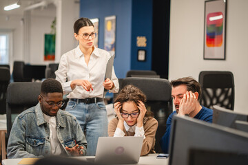 multicultural exhausted colleagues work together on laptop in the office