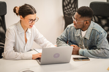 Obraz premium multicultural colleagues work together on laptop in the office