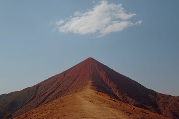 Naklejka premium Lone mountain peak beneath a vast blue sky, symbolizing perseverance and the rewards that await those who pursue their dreams.