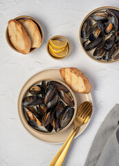 Food photography of mussels with garlic and butter sauce, lemon, toasted bread, seafood appetizer with creamy sauce, starter