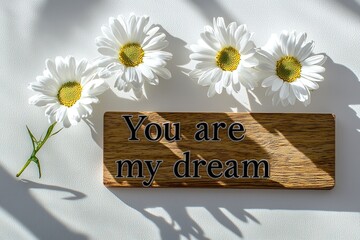"You are my dream" with white daisies placed beside on white background
