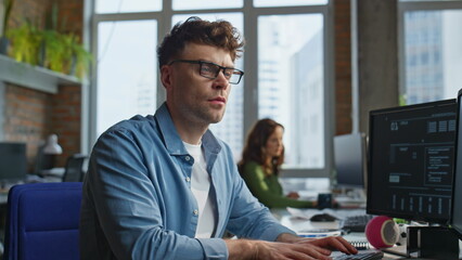 Serious businessman looking computer at office closeup. Focused man working pc