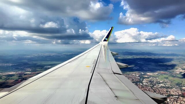 Avi&atilde;o comercial em meio a muitas nuvens e c&eacute;u azul em ponto de vista do passageiro sentado na janela na &aacute;rea da asa. Regi&atilde;o da cidade de Vit&oacute;ria em Espirito Santo, Brasil. 