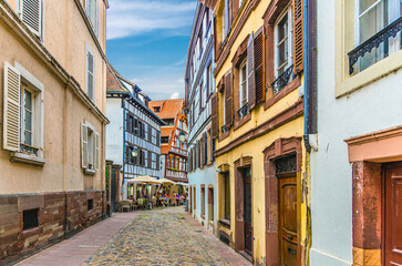 Narrow pedestrian street with old houses, fachwerk style medieval buildings and street restaurant in old town Strasbourg city historic Centre Ville Grande ile Grand Island, Alsace region, France