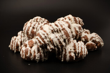 Profiteroles with coconut cream on a black background.