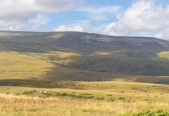 autumn, the morning light of the rising sun illuminates the alpine meadows and the slopes of the mountain range