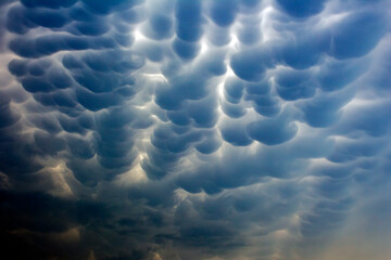 Puffy, surreal clouds form a stunning pattern in the sky, creating a dramatic and mysterious...