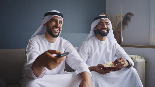 Cinematic video of two friends spending time together in a modern apartment in the united arab emirates. Emirates people with the traditional white kandura in Dubai.