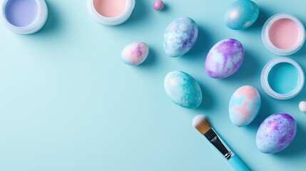 Obraz premium Colorful decorative eggs and painting supplies arranged creatively on a light blue surface during spring celebrations