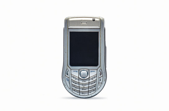 Retro silver cellphone with scratched screen on white backdrop