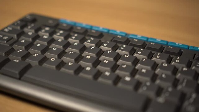 Close-up View of a Sleek Modern Wireless Keyboard on a Wooden Desk Surface