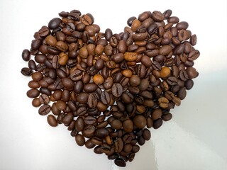 heart made of coffee beans on a white background hands forming a heart caffeine drink