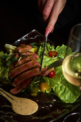 red meat steak with vegetables next to a glass of white wine