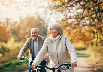 Happy senior couple riding bicycles together in a beautiful autumn park