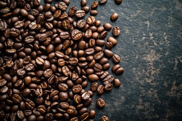 Fototapeta premium Freshly roasted coffee beans scattered on a textured surface showing deep brown colors and rich textures typical of high-quality beans