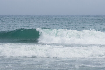 Seascape. View of the waves and surf. Windy weather. Waves, foam and ripples on the surface of sea water. Summer landscape. The expanses of the Pacific Ocean. Beautiful natural background. Nobody.