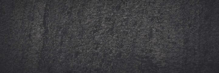 Dark gray granite texture. Natural granite with a grainy pattern. Solid rough surface of rock with spots, noise and grain. Dark stone background for design. Shaded texture with vignette.