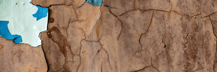 Peeling paint on the wall. Panorama of a concrete wall with old cracked flaking paint. Weathered...
