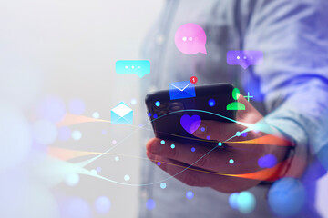 Social media concept. Man holds smartphone with social media icons and digital waves.