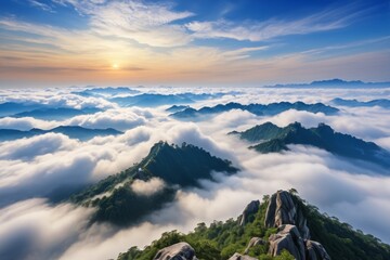mountains covered in clouds and trees with a sun setting