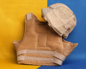 military body armor and helmet against the background of the Ukrainian flag. Concept of combat operations in this country