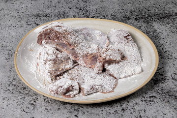 A plate full of raw uncooked pork or beef liver covered with flour ready for frying