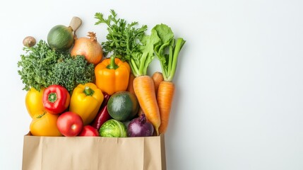 Fresh fruits and vegetables in a paper bag on a white background.  This shows healthy eating and food delivery or shopping.

