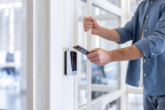 Man uses his smartphone to access a secure area, highlighting modern security technology and mobile access solutions.