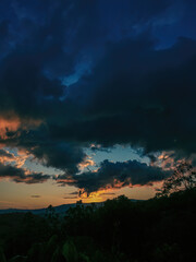 A mostly red afterglow casted on big dense clouds by the light of  the sunset, over the western Andean mountains of central Colombia, near the town of Villa de Leyva.