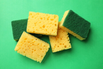Soft sponges on green background, top view. Cleaning tool