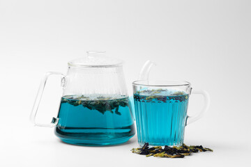 Fresh butterfly pea flower tea and dry petals on white table, closeup