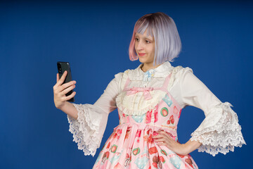 Cosplayer taking a selfie with smartphone wearing colorful costume and wig