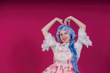 Cosplayer making heart shape with hands and smiling on pink background