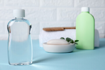 Baby oil and bath accessories on blue table
