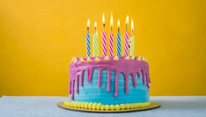 colorful birthday cake with burning candles on it and frosting dripping down