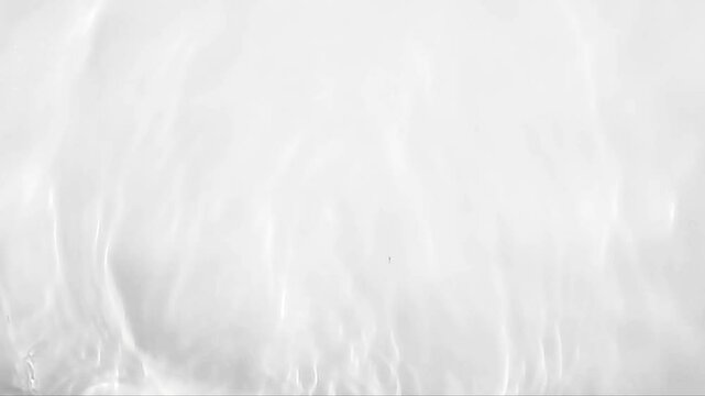 Pure beige water with reflections sunlight in slow motion. Water surface texture top view. Sun and shadows. Motion clean swimming pool ripples and wave.